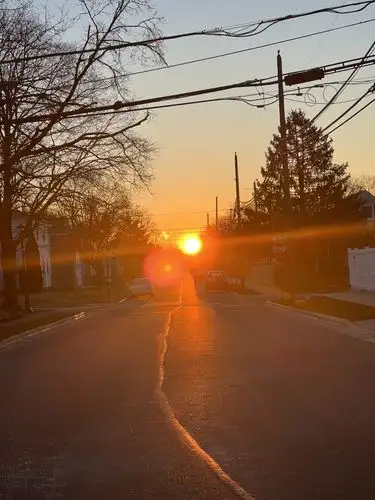 Golden hour glow painting the street with its warm embrace.